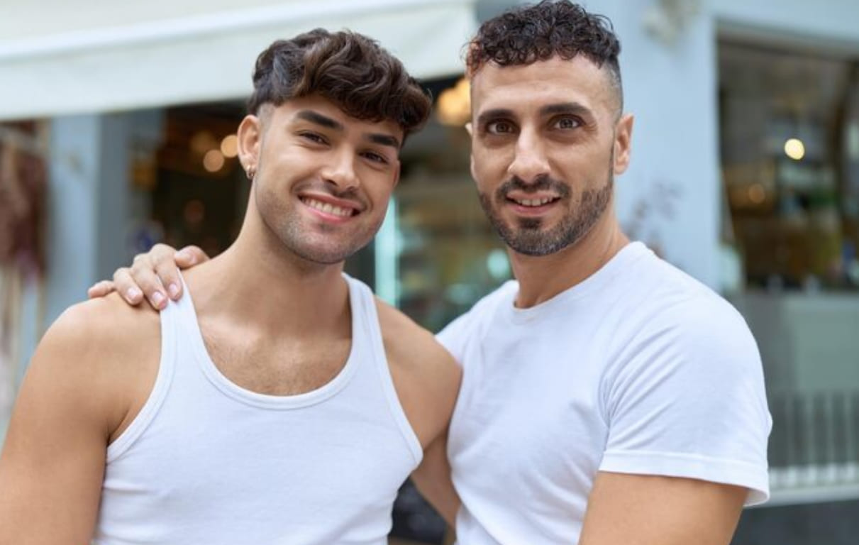 Two gay men smiling during a café date